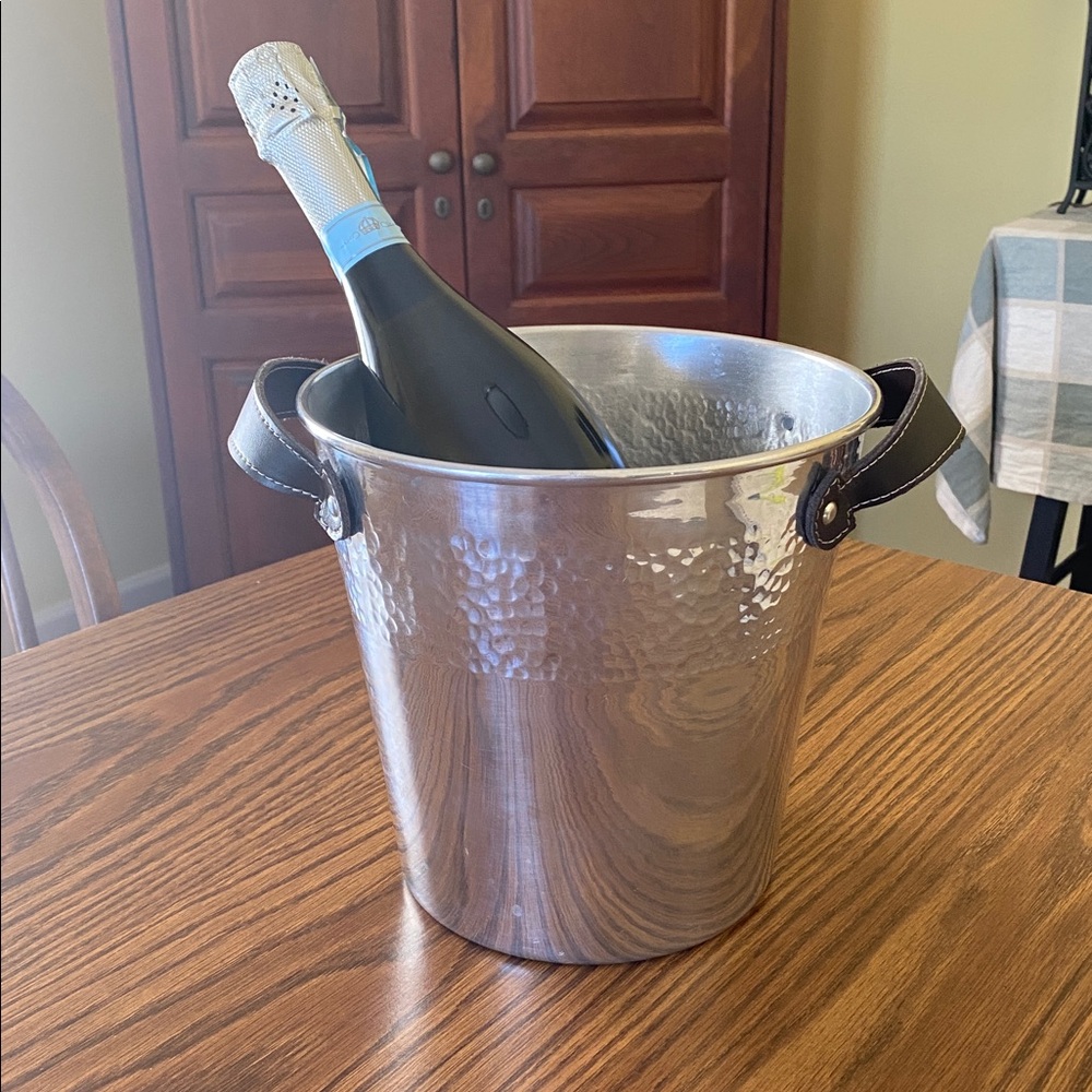 Hammered accent Metal bucket with brown handles and tongs.
